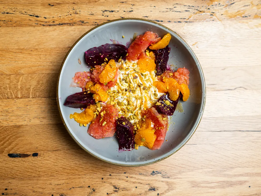 A bowl of roasted beets and citrus segments, from above