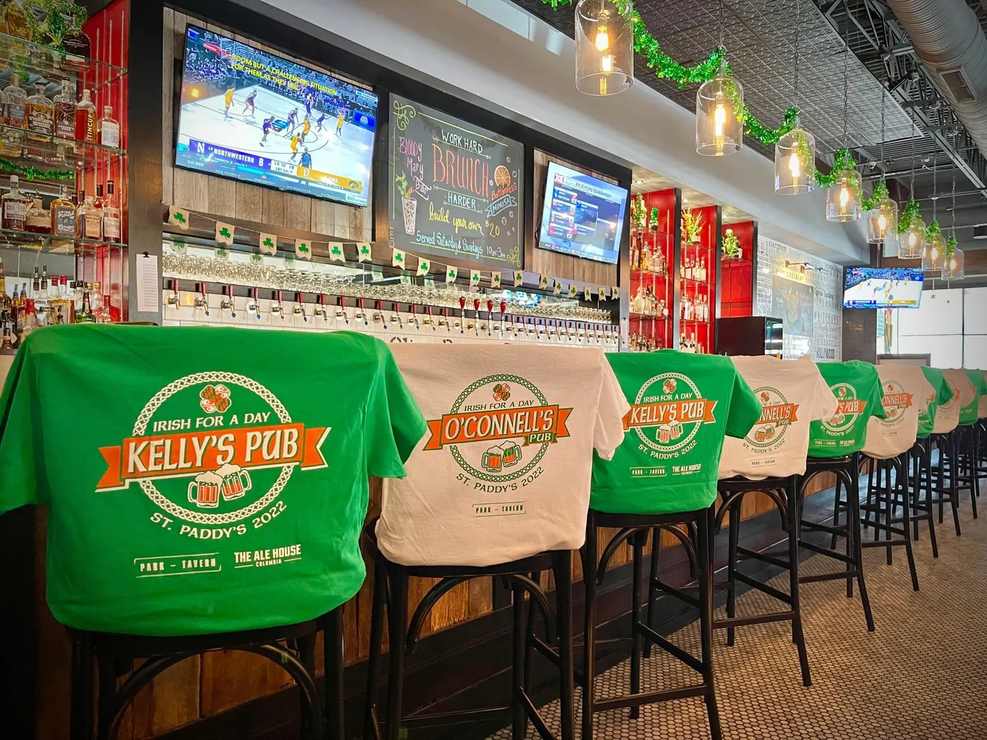 St. Paddy's shirts reading Irish for a Day, Kelly's Pub, draped over the barstools