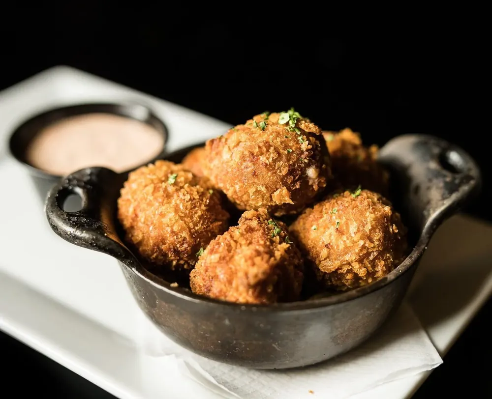 Fried bites in a cast iron dish with dipping sauce